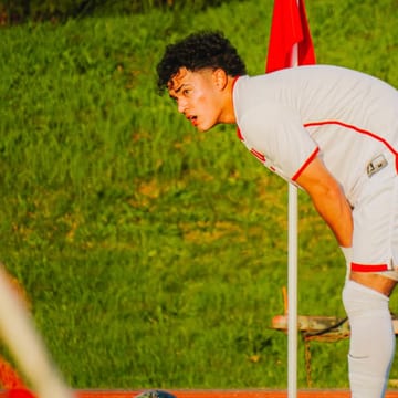 Isaac Reynoso in a white kit next to the corner flag