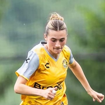 Lucia Wells running in the yellow Pittsburgh kit