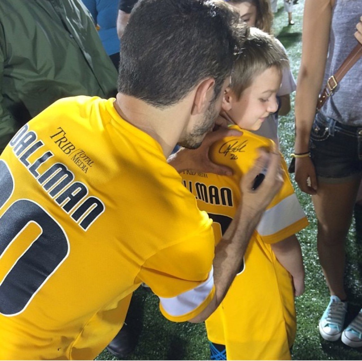 Matt Dallman signing a young fan's Riverhounds jersey