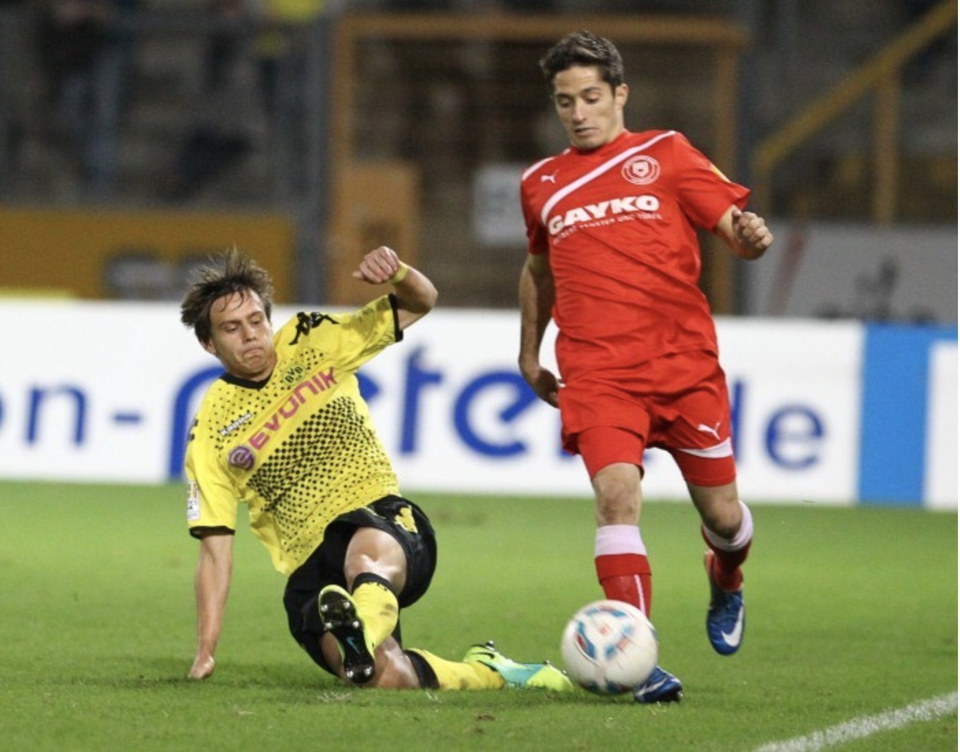 Matt Dallman in a yellow jersey striking the ball during a match